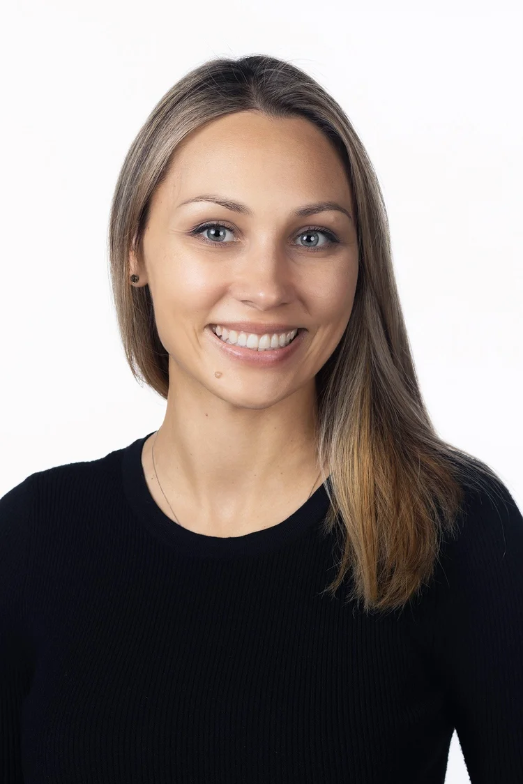 Professional woman with long hair in a black top on a white backdrop