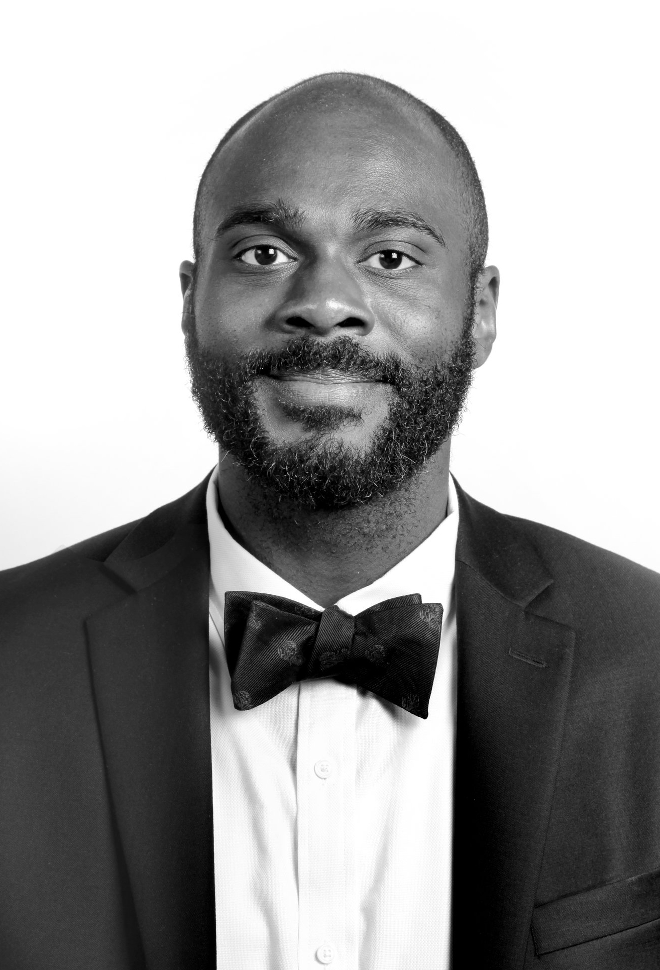 Black and white portrait of a man in a tuxedo and bow tie