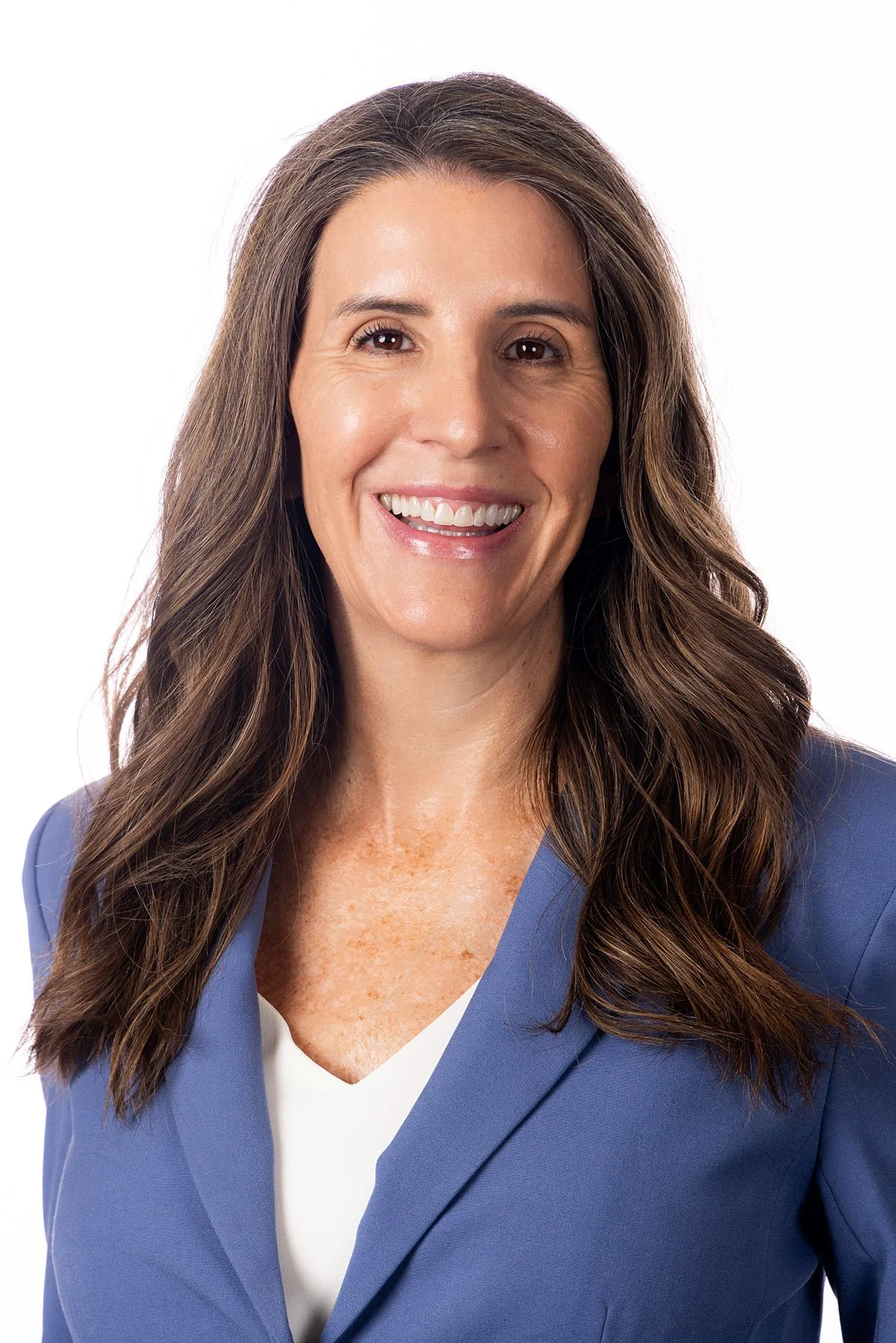 Professional woman with long brown hair in a periwinkle blazer on white