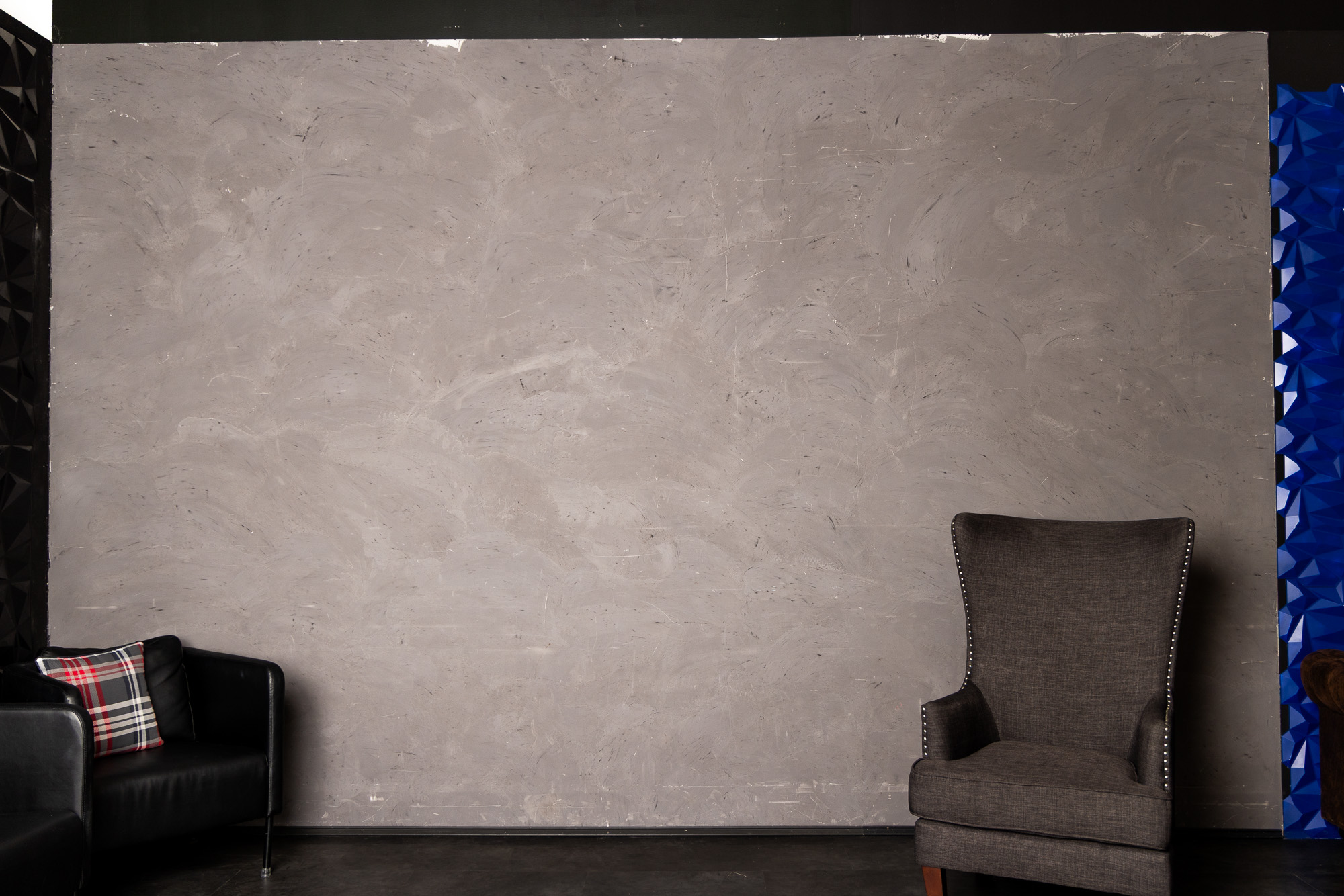 Hand-troweled grey plaster backdrop with lounge seating