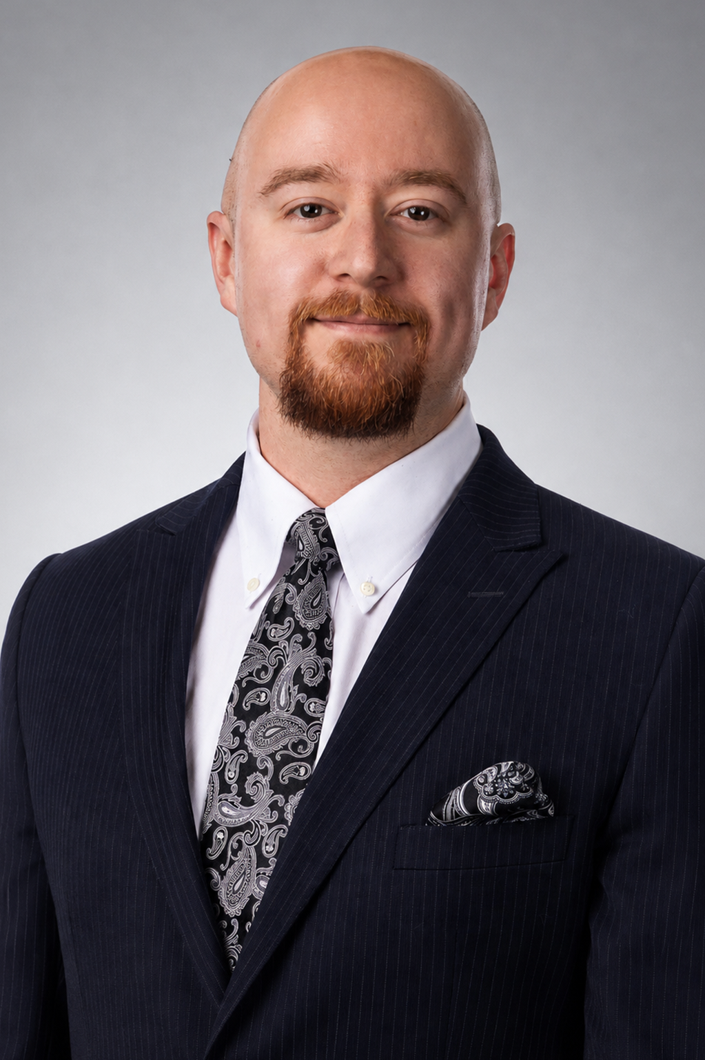 Executive in a navy pinstripe suit and paisley tie