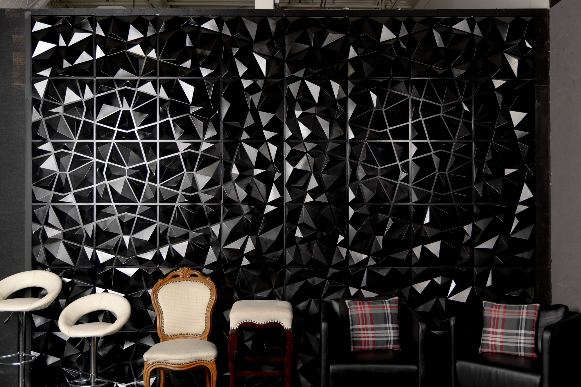 Black faceted feature wall with vintage seating