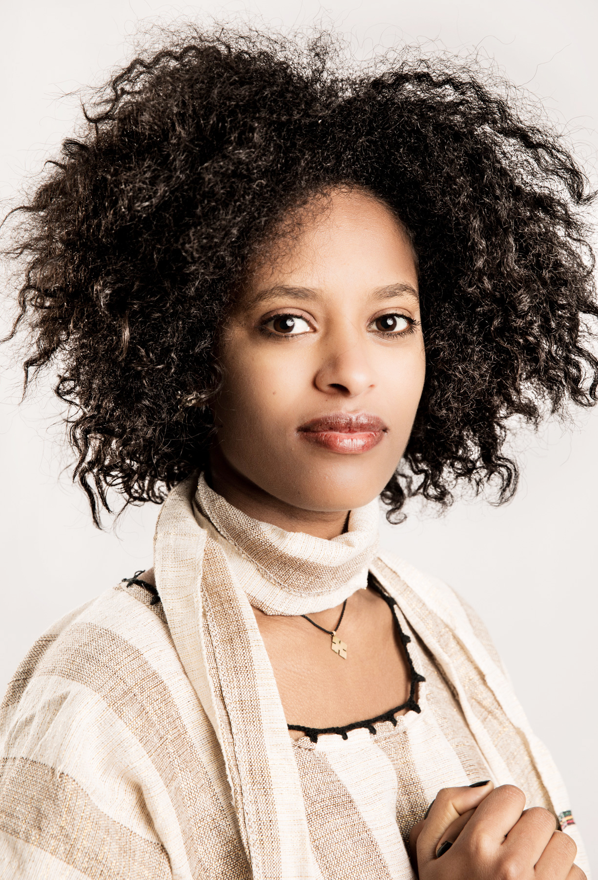 Woman with curly hair in a cream woven wrap