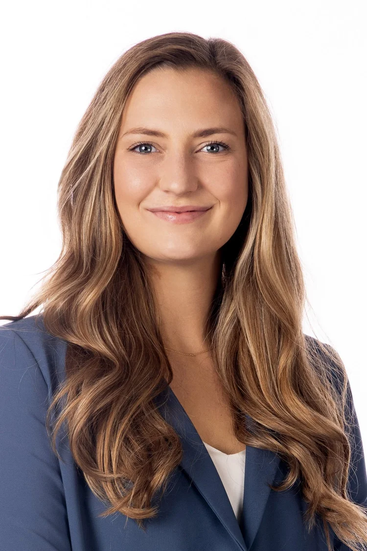Professional woman with long blonde hair in a blue blazer on white