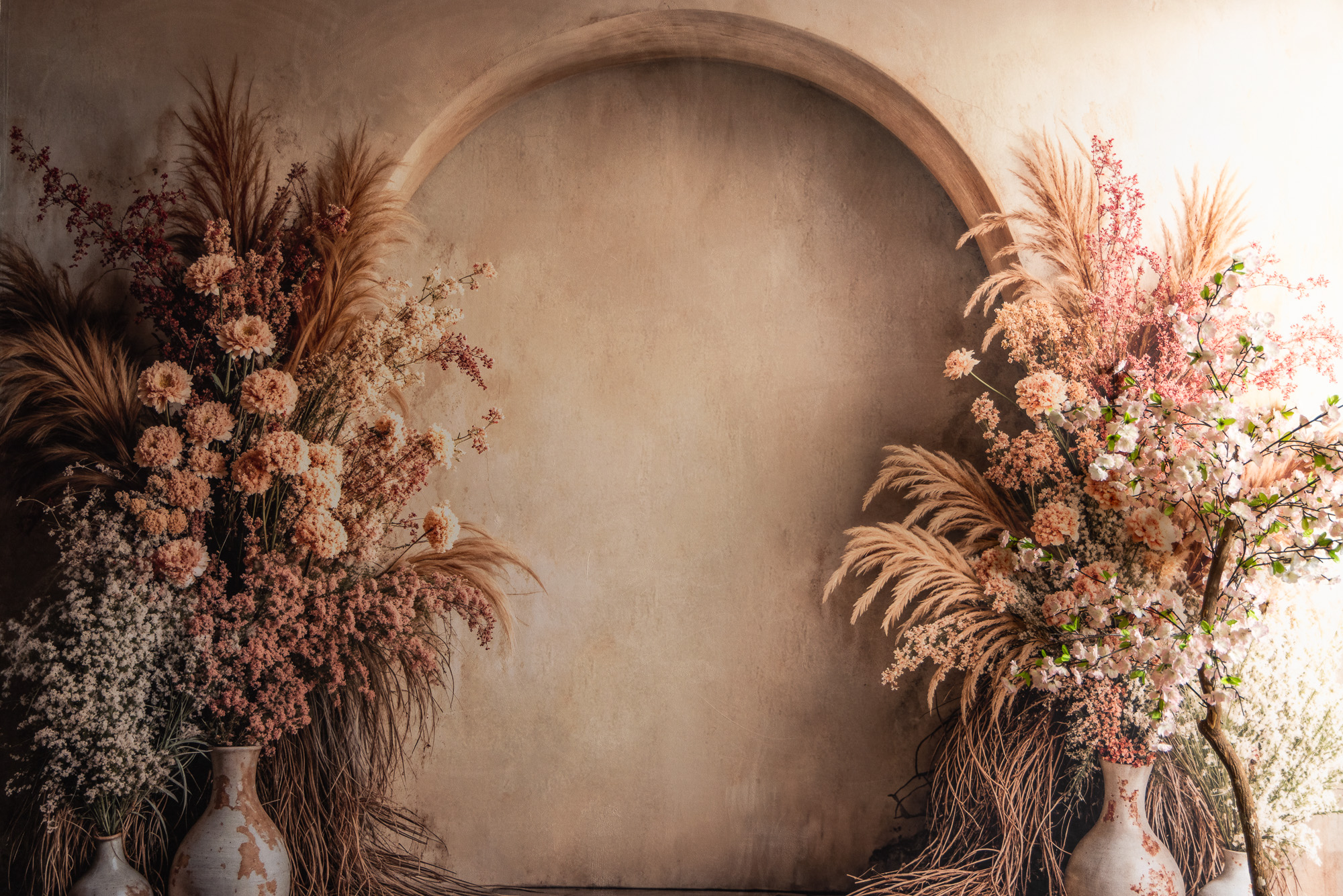 Warm arch backdrop framed with dried florals